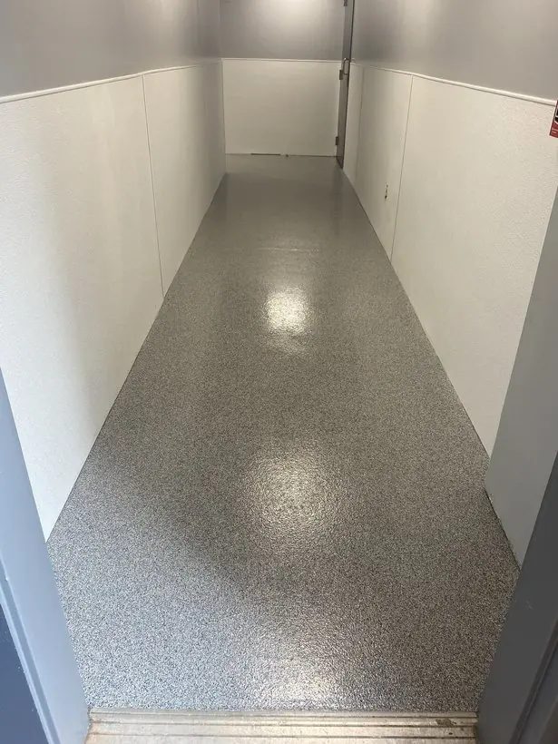 Service hallway — coated tight to the wall panels, no gaps — epoxy flake flooring by Vibrant Painting, Greenville SC